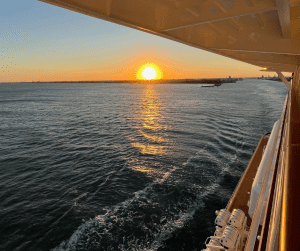 The best cruise ship for you will have the best views. Image of a sunset over the open ocean from a balcony.